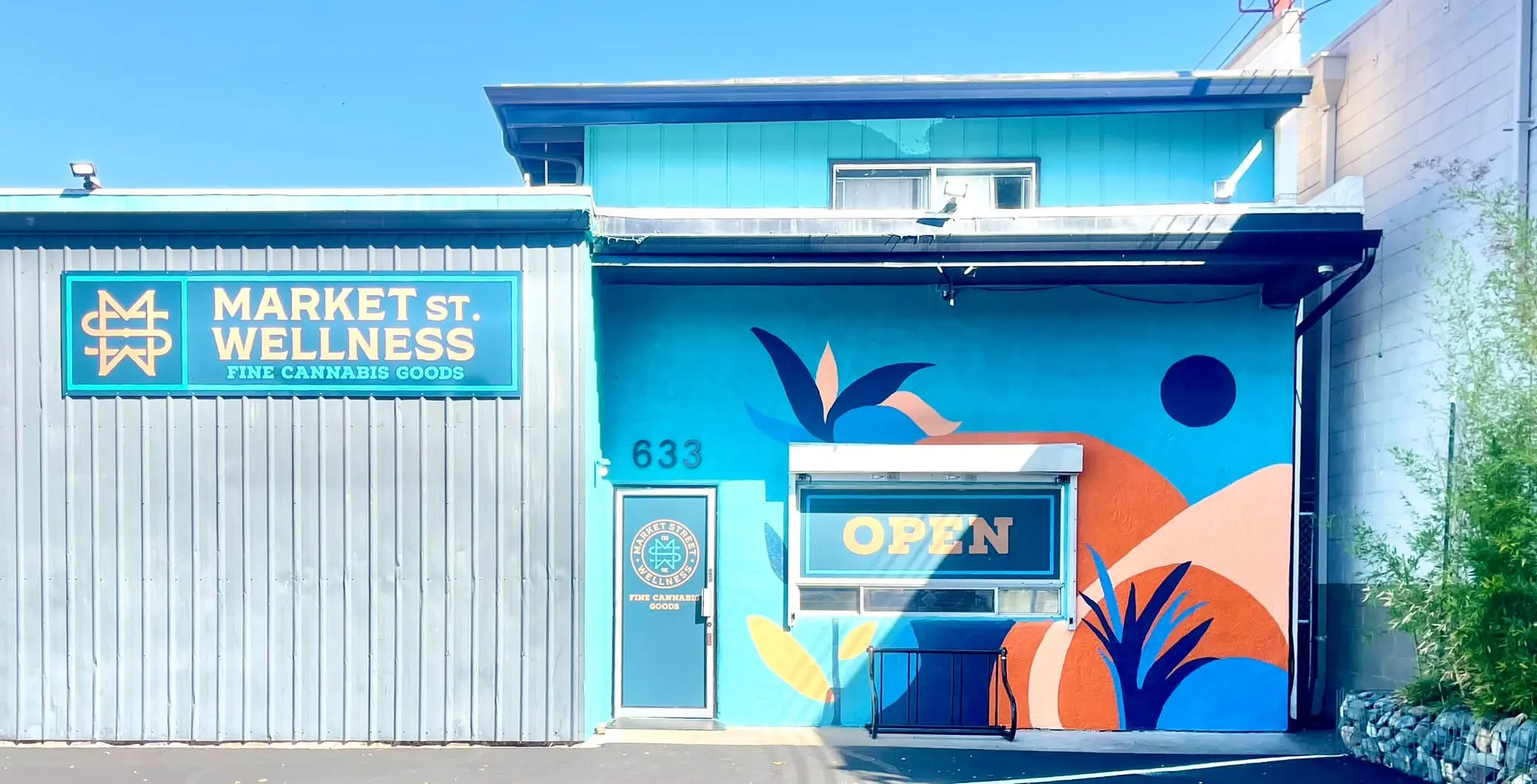 The Market St. Wellness storefront at 633 Market Street: a bright blue building with a hand-painted mural and an OPEN sign in the window